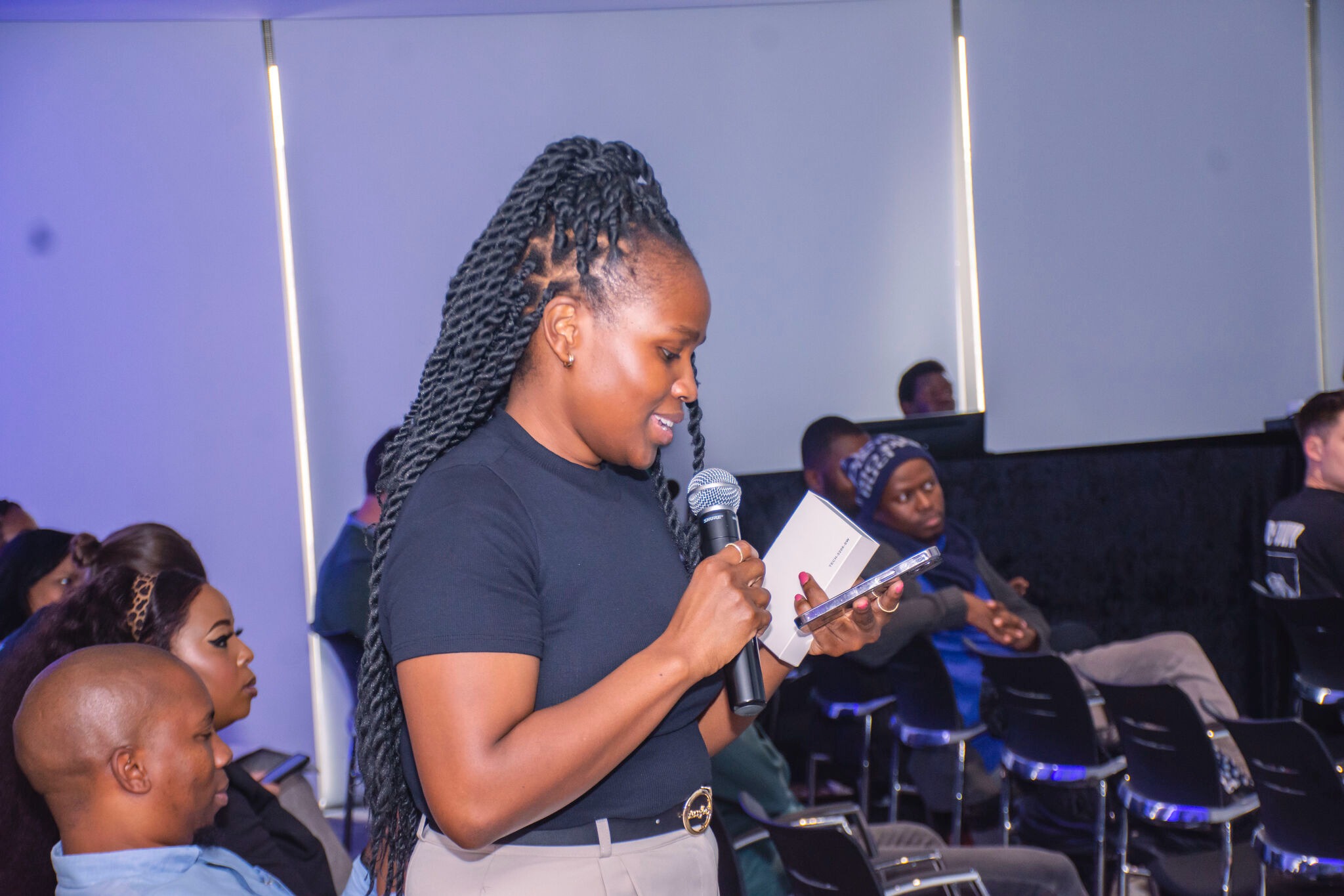 Ntsiki Sackey addressing the room at a panel event, microphone in hand